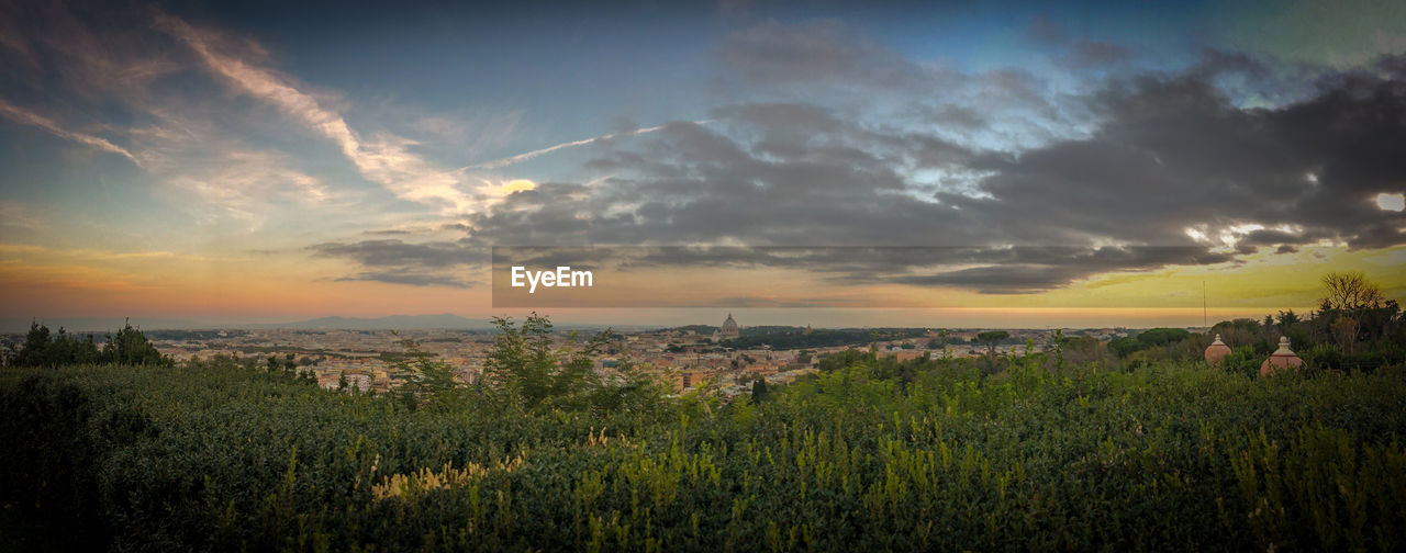 Aerial view of townscape against cloudy sky during sunset