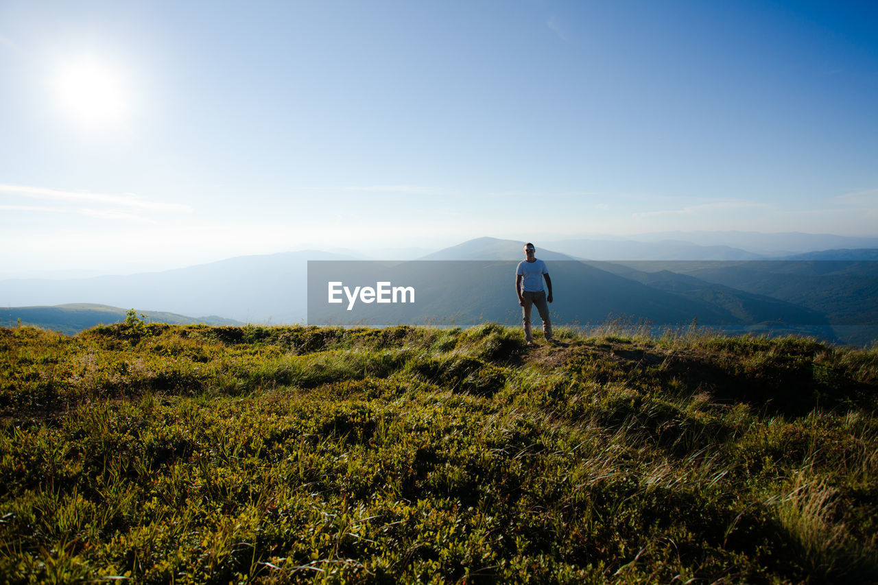 Man on field against mountain range