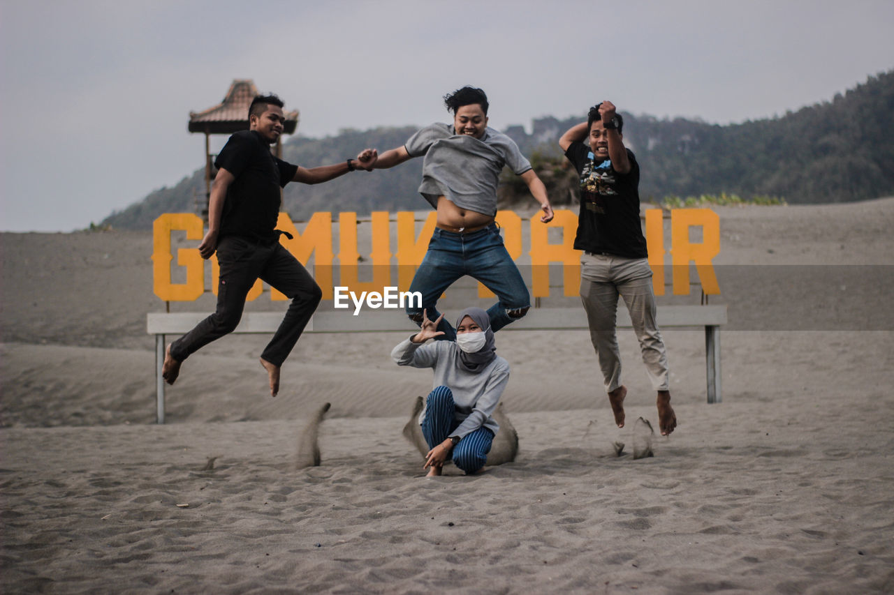 Happy friends jumping at beach