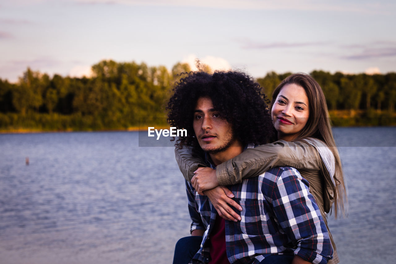  north african man and asian woman enjoying playful fun piggyback with smile for holiday in nature