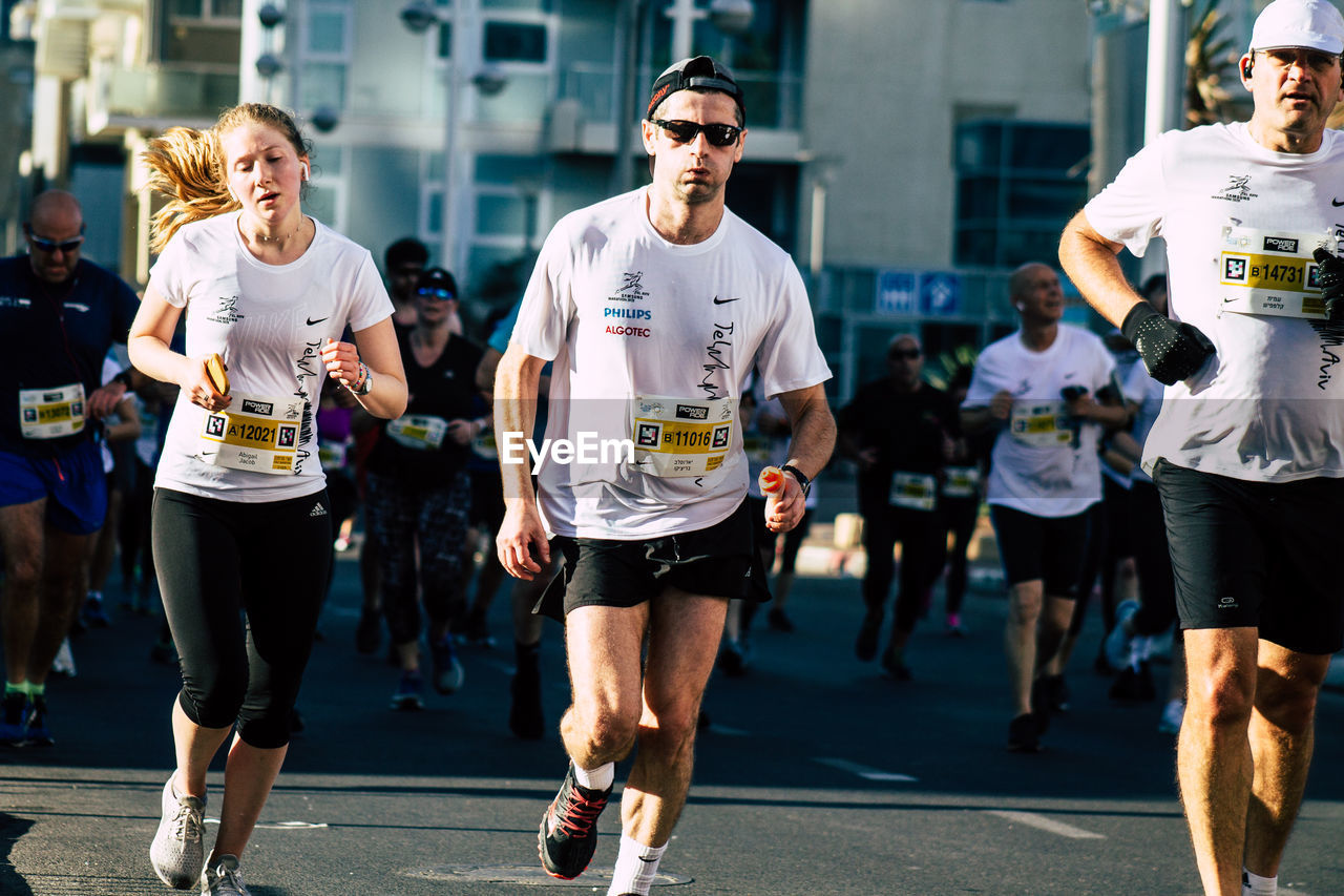 GROUP OF PEOPLE RUNNING ON STREET