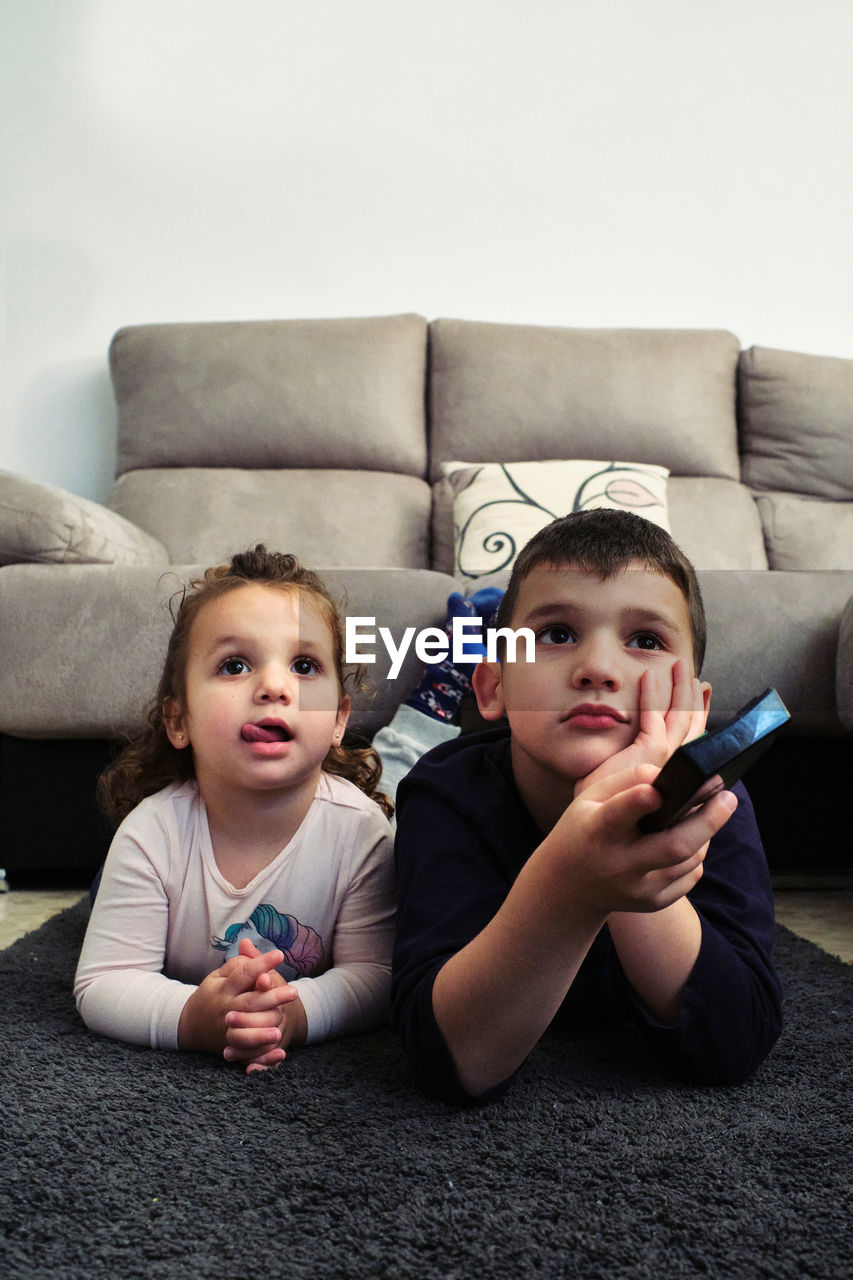 Siblings watching a home movie while eating popcorn