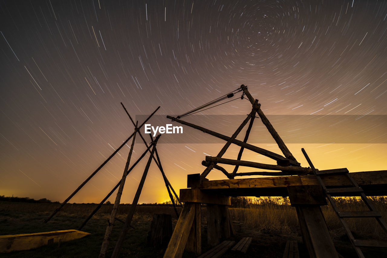 Low angle view of star trails against sky at night