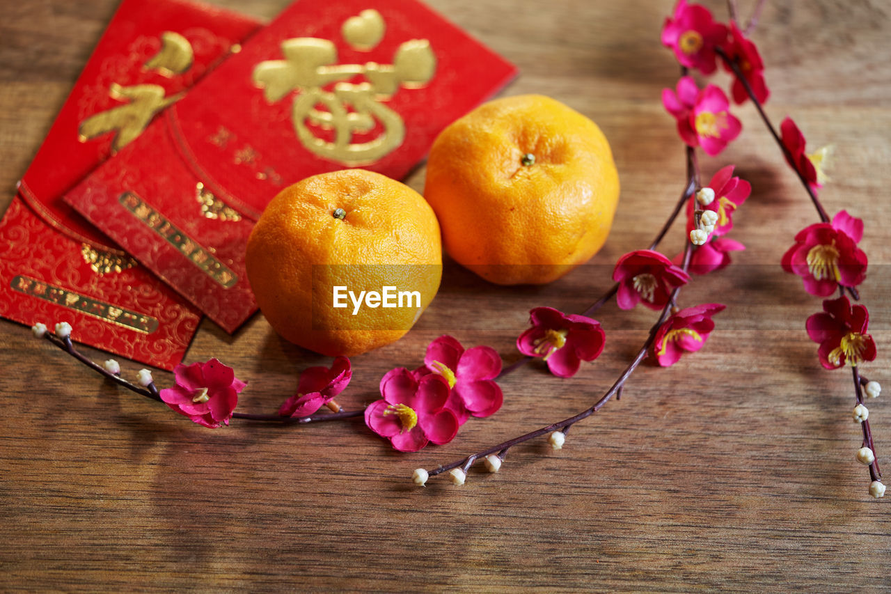 Mandarin oranges and the plum blossom on red background