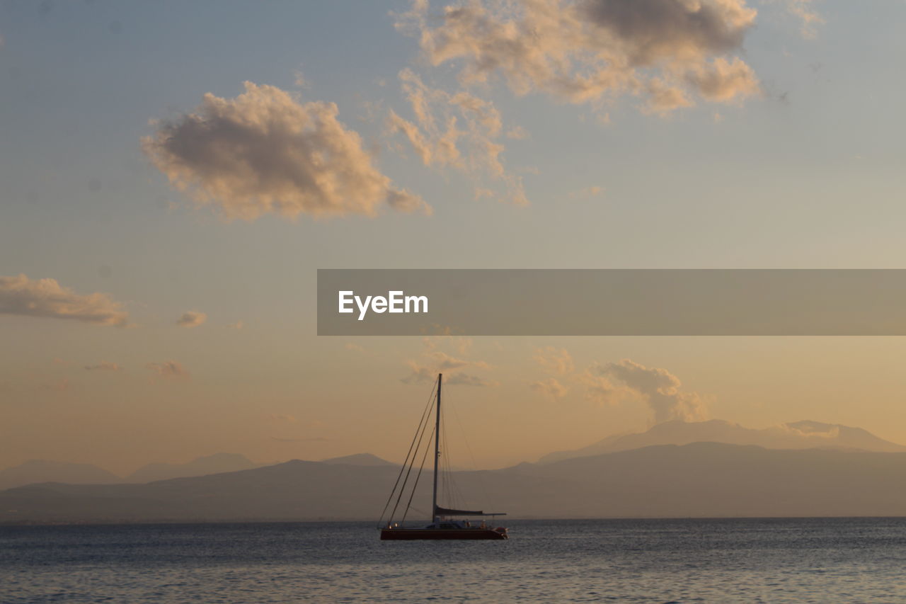 SAILBOATS SAILING ON SEA AGAINST SKY DURING SUNSET