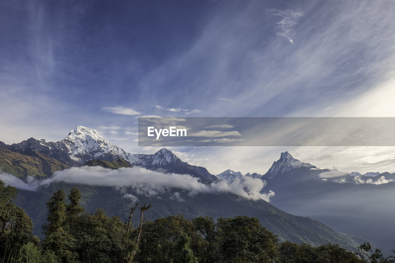 Scenic view of snow mountains against blue sky