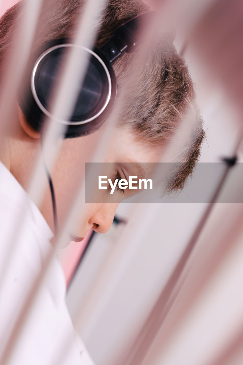 Side view of thoughtful boy wearing headphones