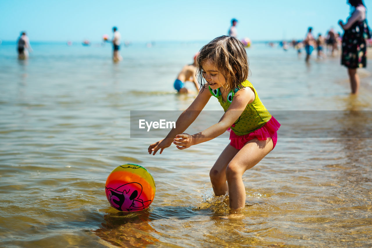 Girl playing with ball at beach