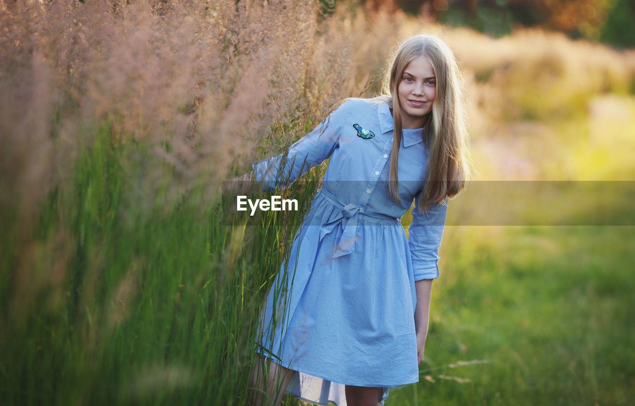 Teenage girl long blond hair on grass. pretty happy girl enjoying summer in park. beautiful model 