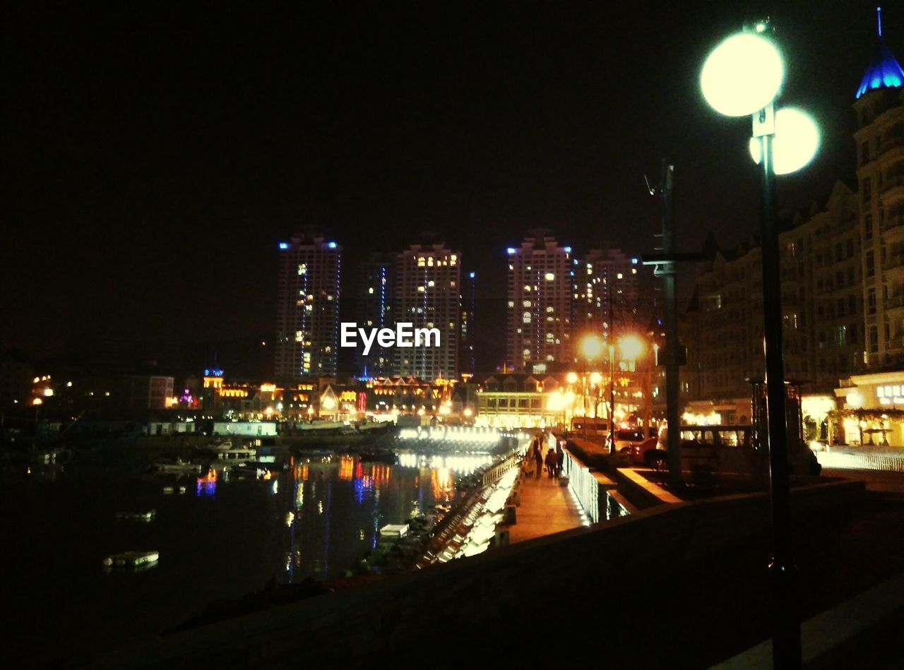 ILLUMINATED BUILDINGS IN CITY AT NIGHT