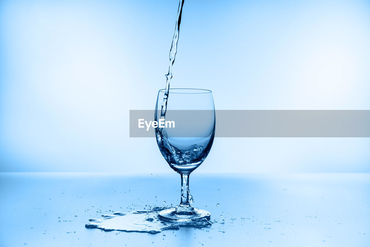 CLOSE-UP OF WATER SPLASHING ON GLASS