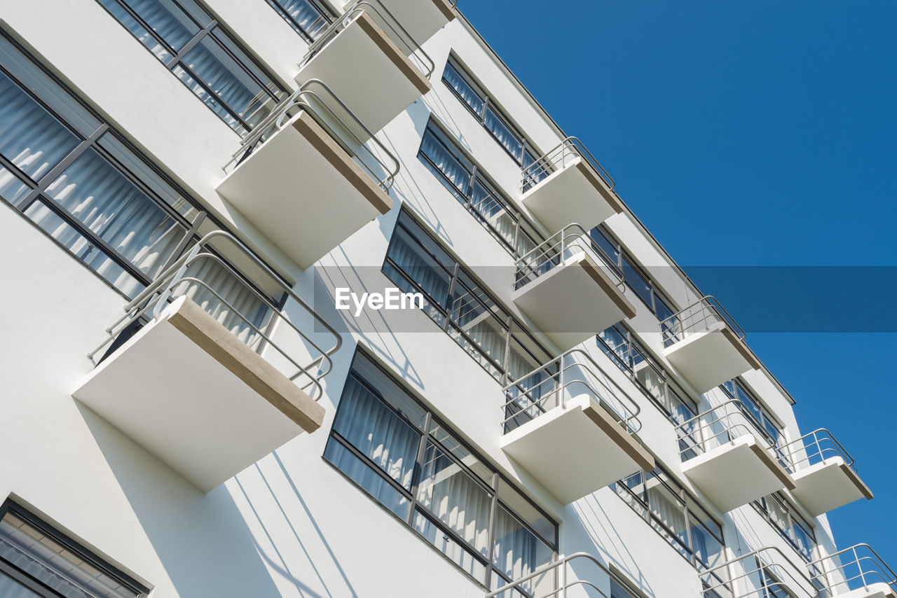 Low angle view of buildings against clear blue sky