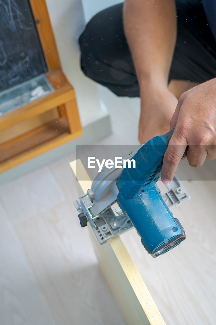 Hand held worm drive circular saw cutting boards at home. diy renovation makeover project.