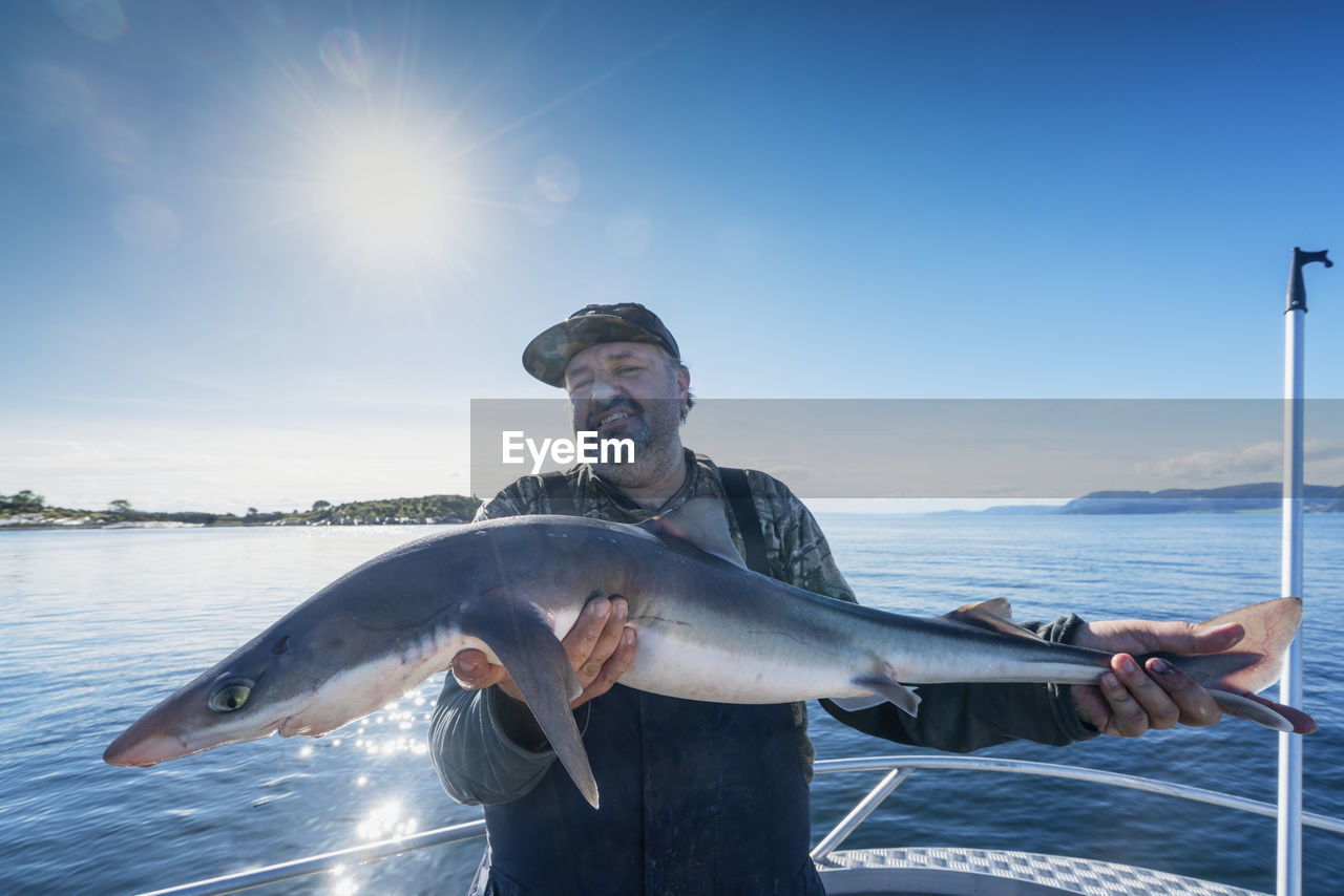 Man on boat holding fish