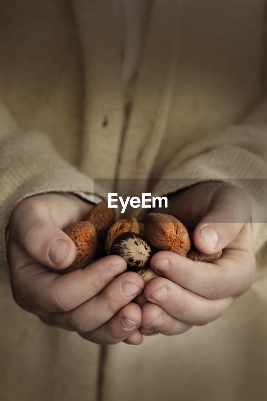 Midsection of woman holding almonds