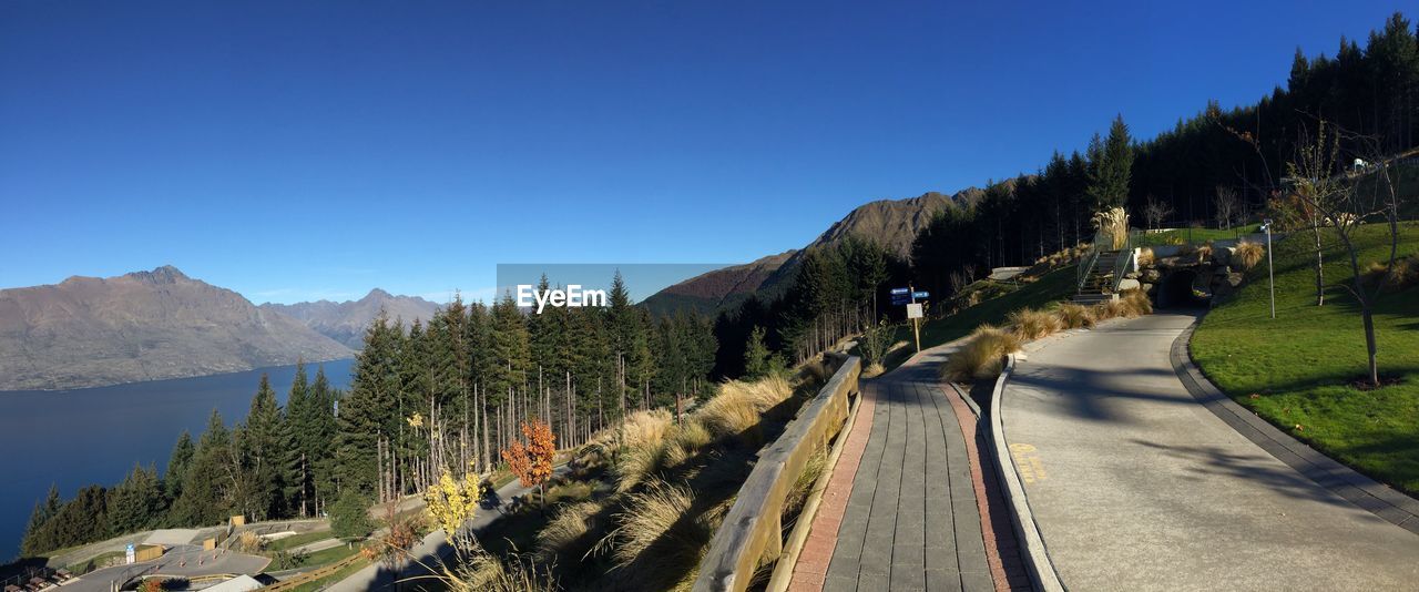 Panoramic view of trees and mountains against clear blue sky