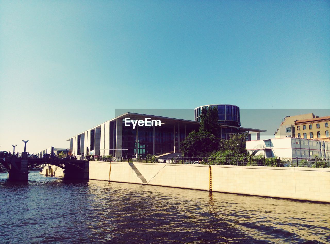 RIVER BY BUILDINGS AGAINST CLEAR SKY