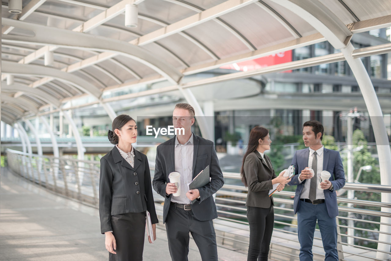 Business people discussing while standing on elevated walkway