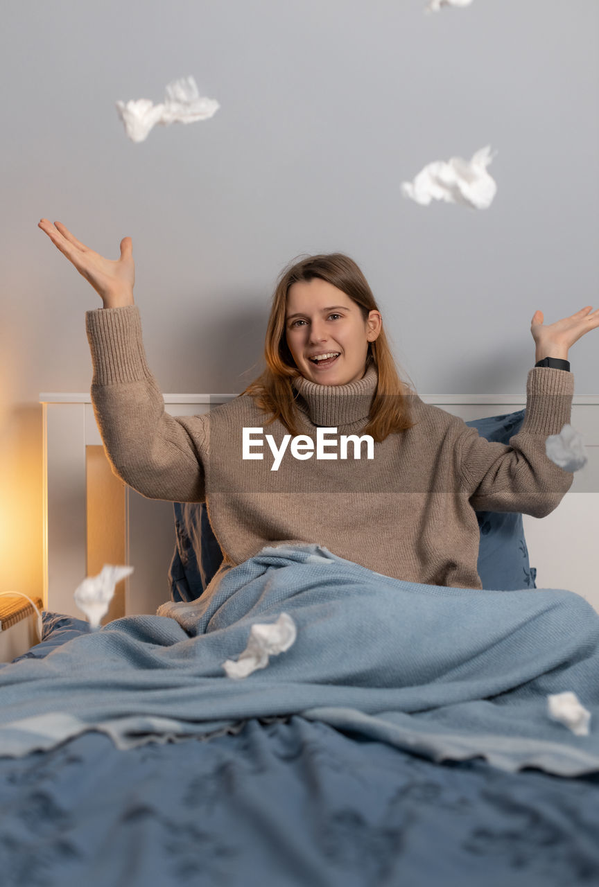 Cute girl throws up crumpled paper napkins. woman enjoy about getting better after an illness.