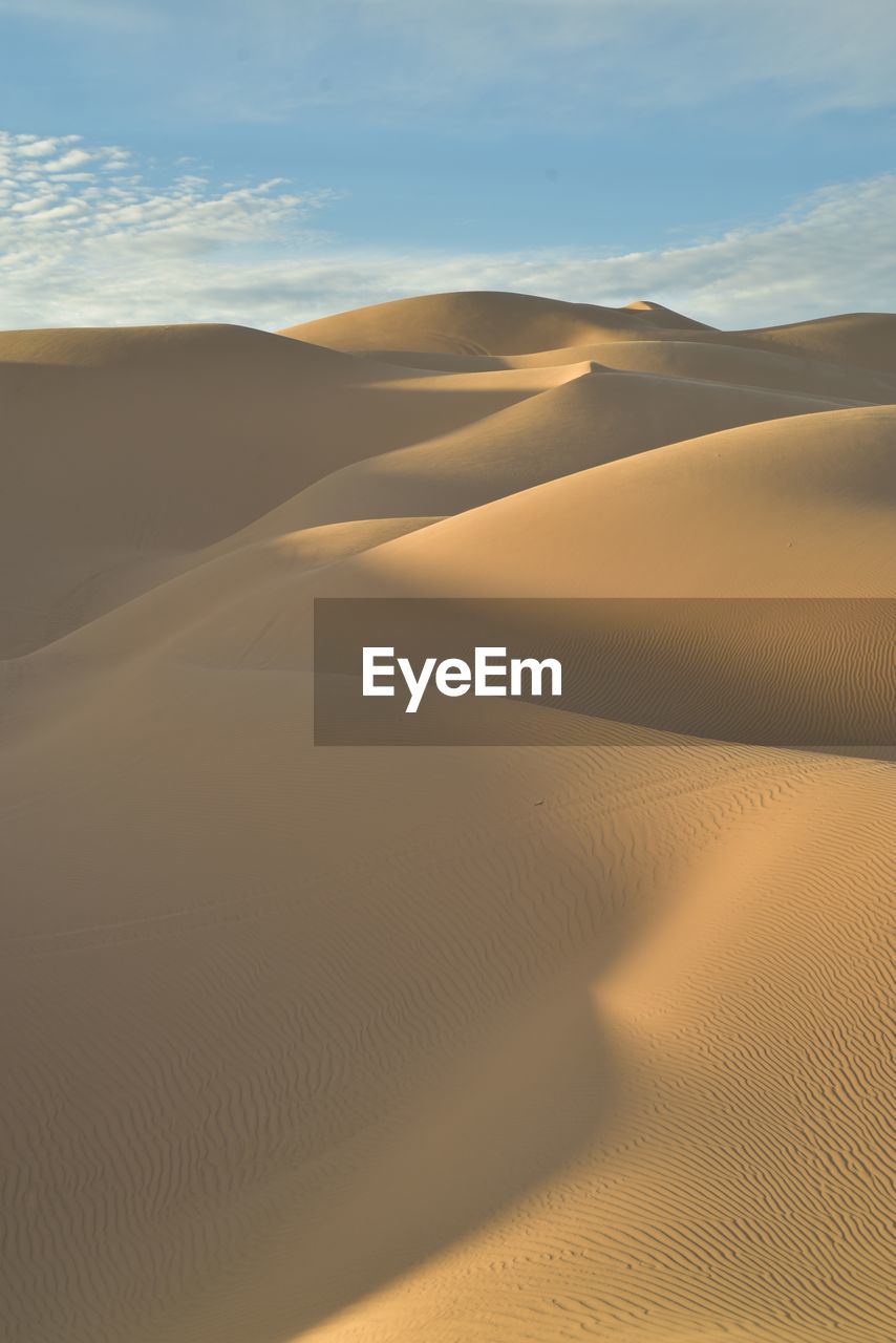 Sand dunes in desert against sky