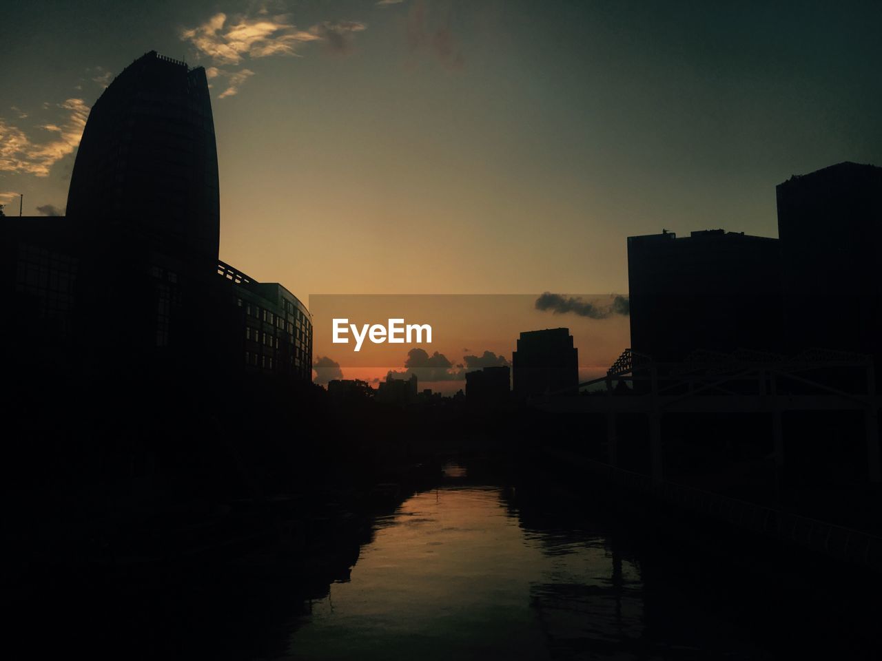 SILHOUETTE OF BUILDINGS AT WATERFRONT