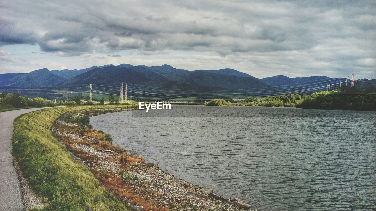 Scenic view of road amidst river and mountain