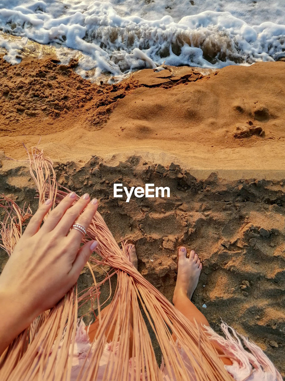 Midsection of woman holding hands on land