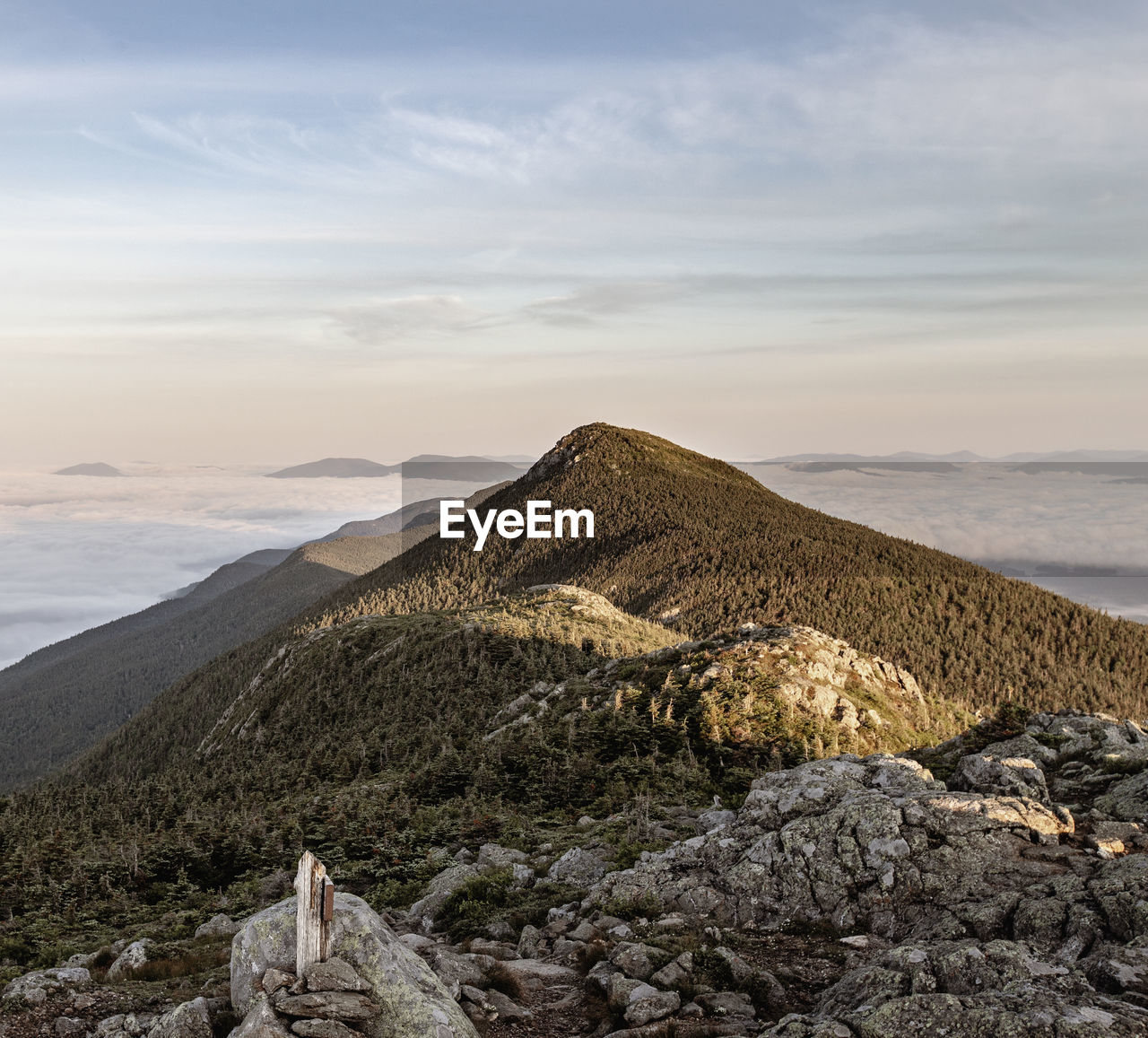 Bigelow mountain, maine, rises above clouds at sunrise