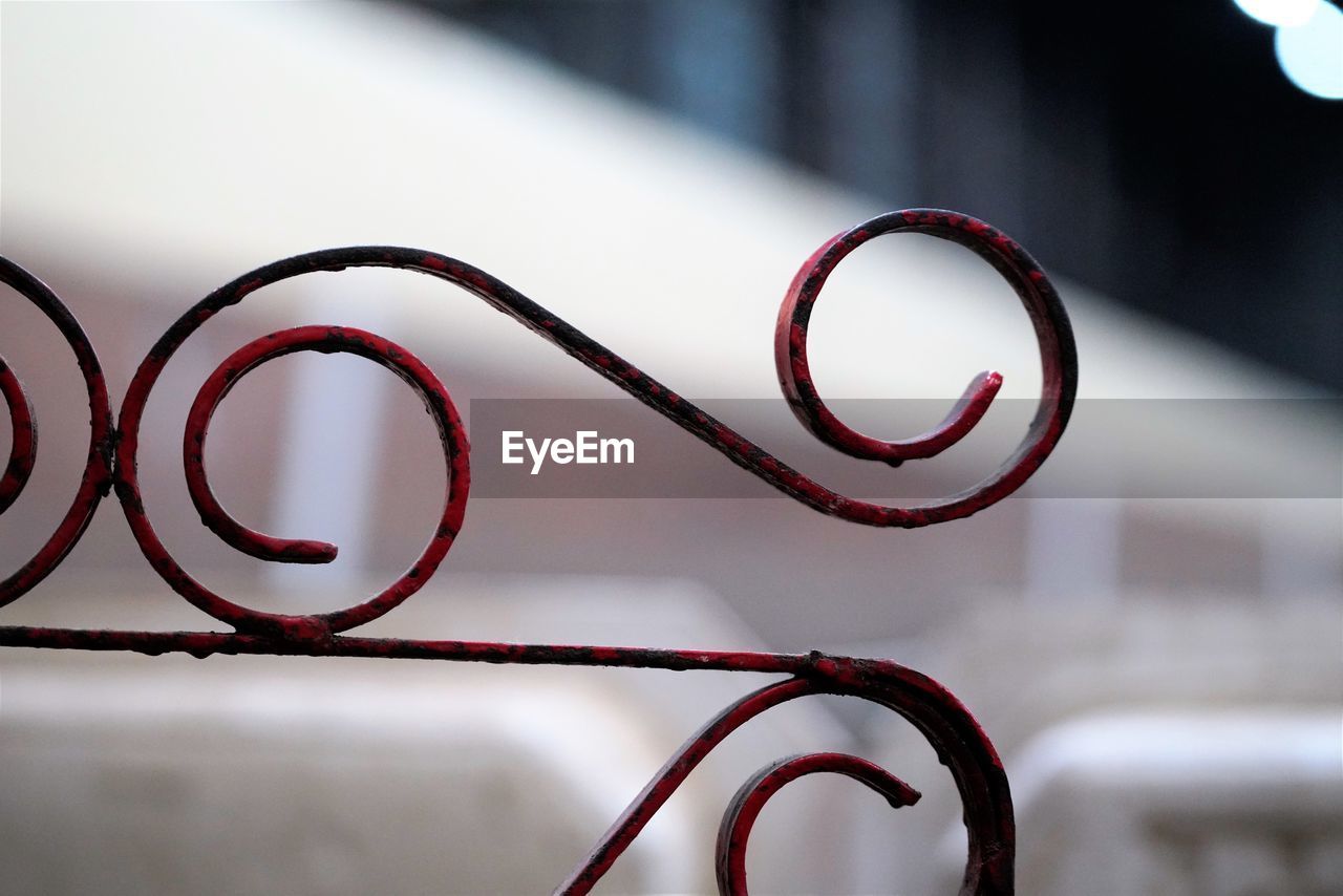 red, close-up, glasses, white, pink, no people, iron, circle, light, focus on foreground, font, spiral, black, indoors