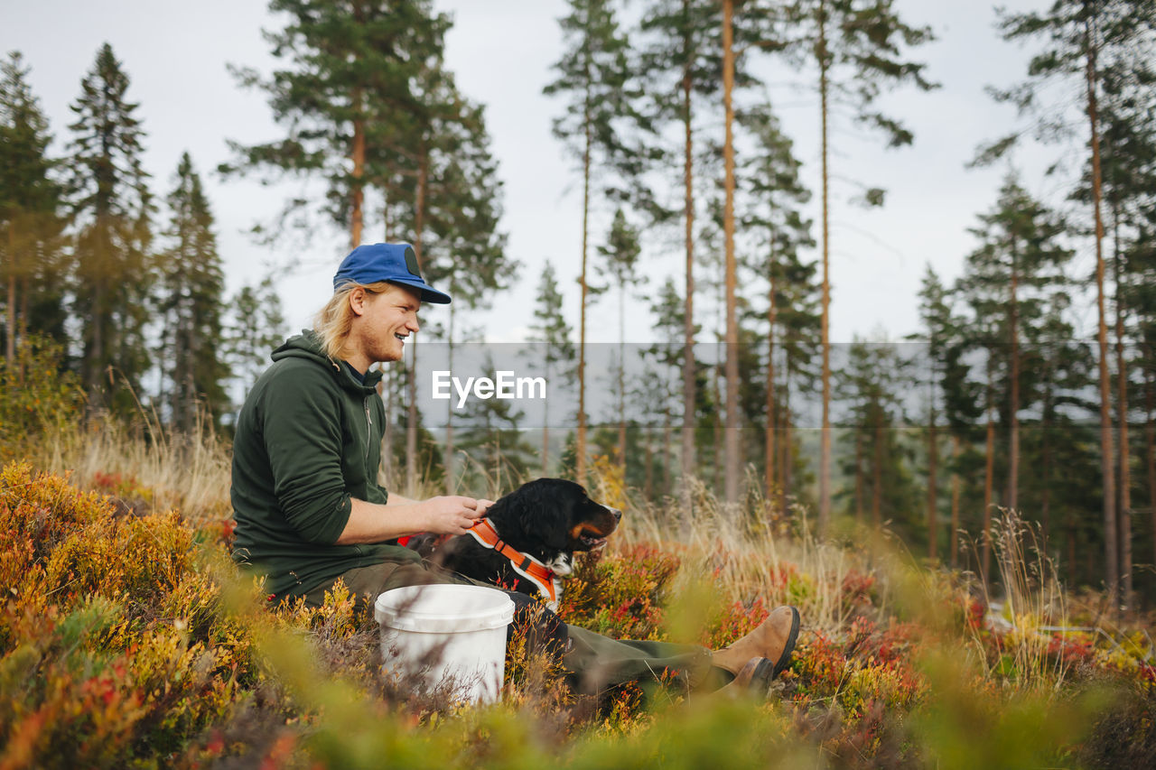 Smiling man with dog looking away