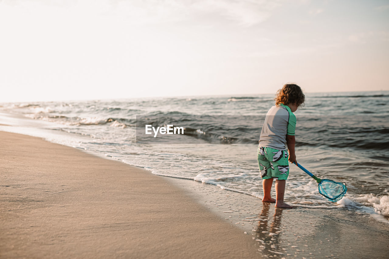 Boy on beach at sunrise