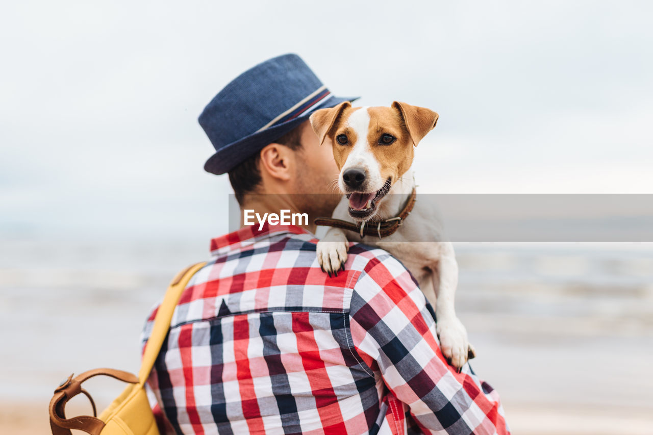 PORTRAIT OF MAN WITH DOG IN SEA