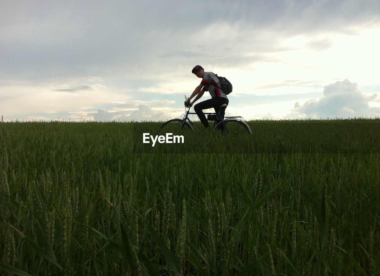 Man riding bicycle on grassy field