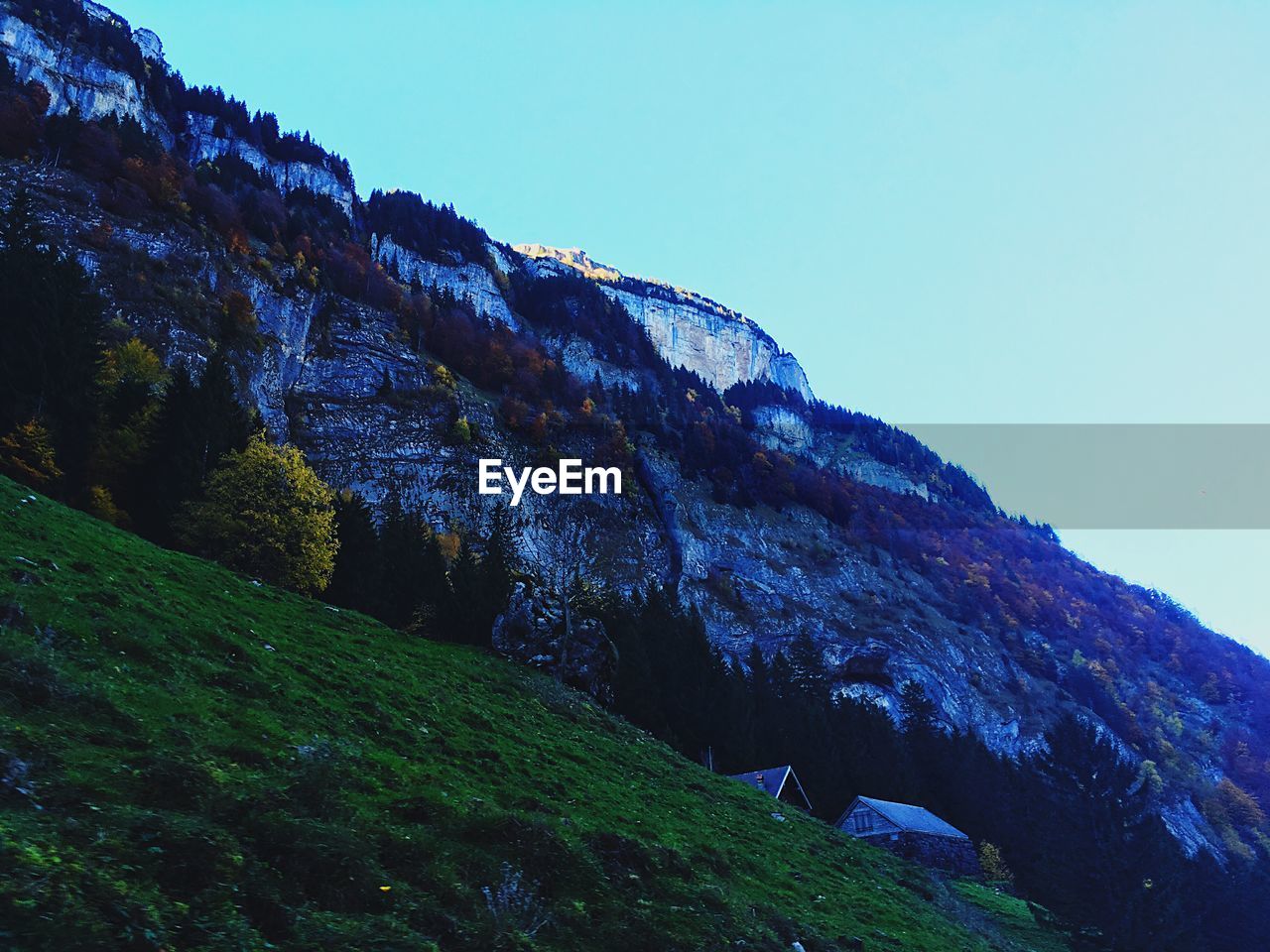 Low angle view of mountain against clear blue sky