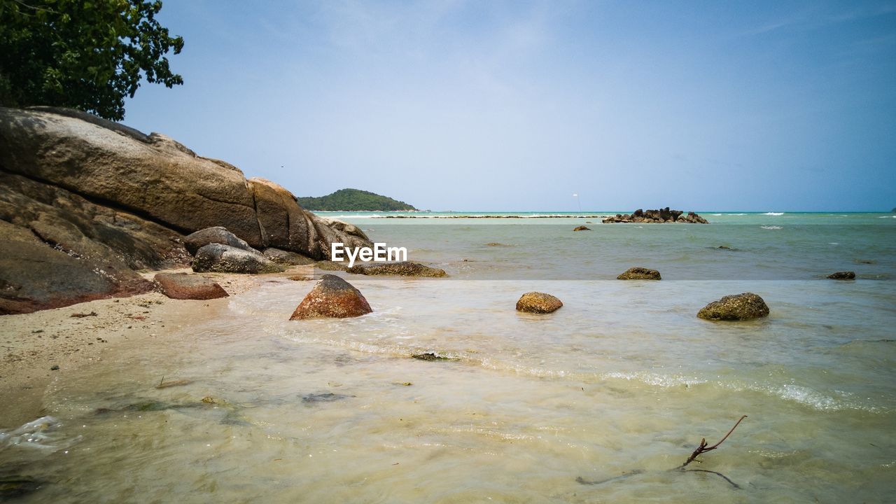 ROCKS ON SHORE AGAINST SKY