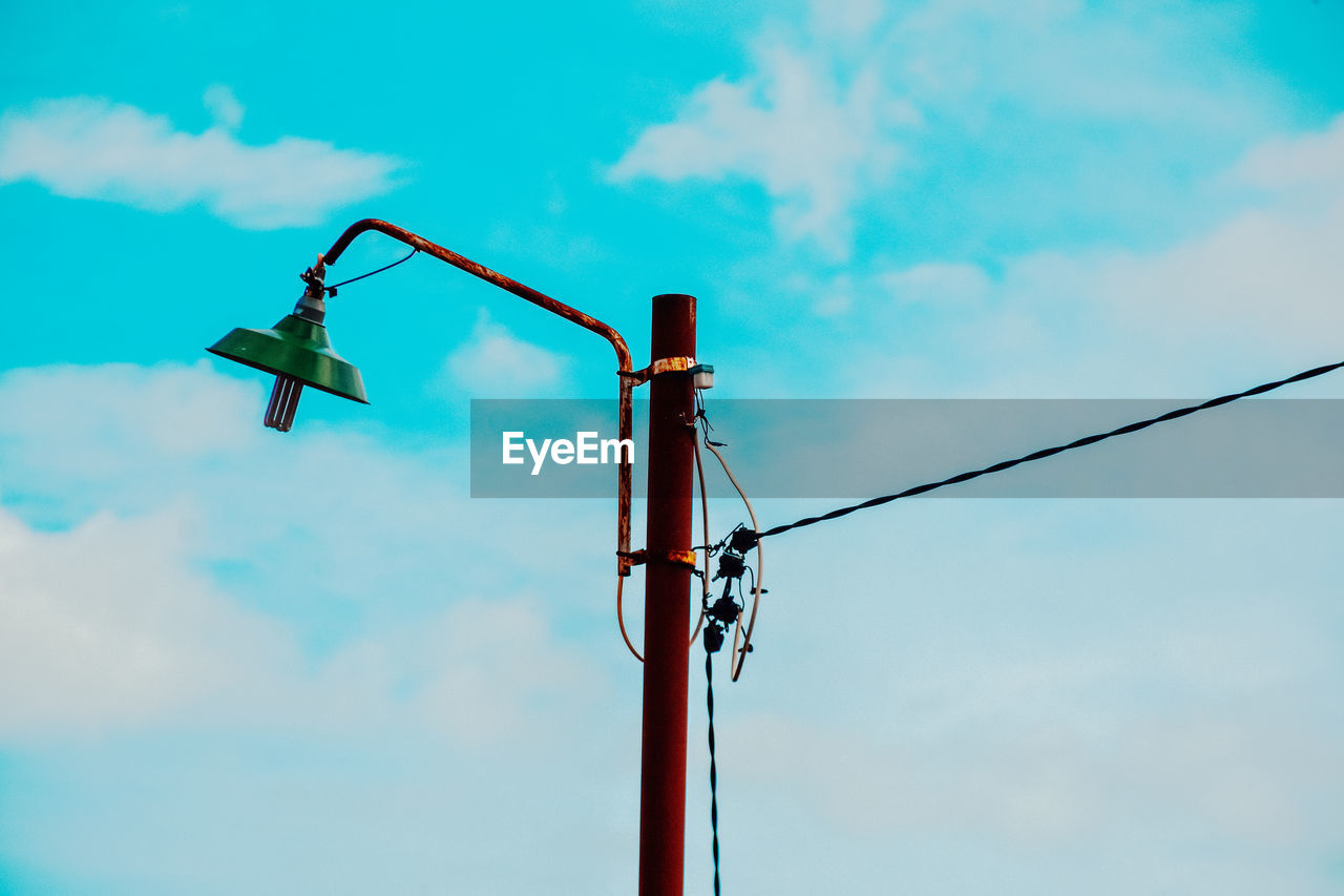 Low angle view of street light against blue sky