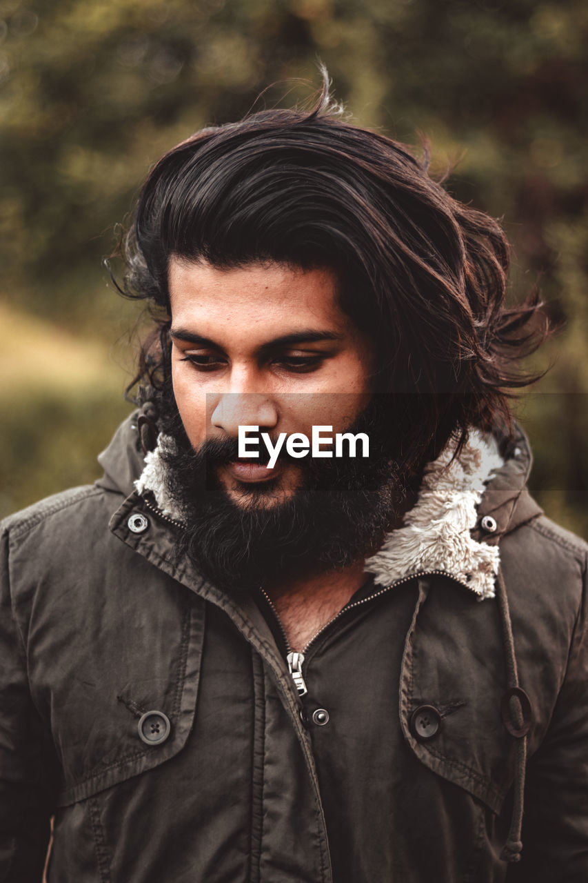 Close-up of bearded young man looking away outdoors