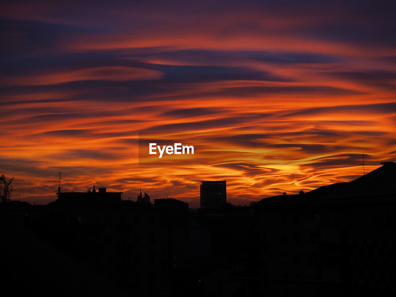 Silhouette buildings against sky during sunset