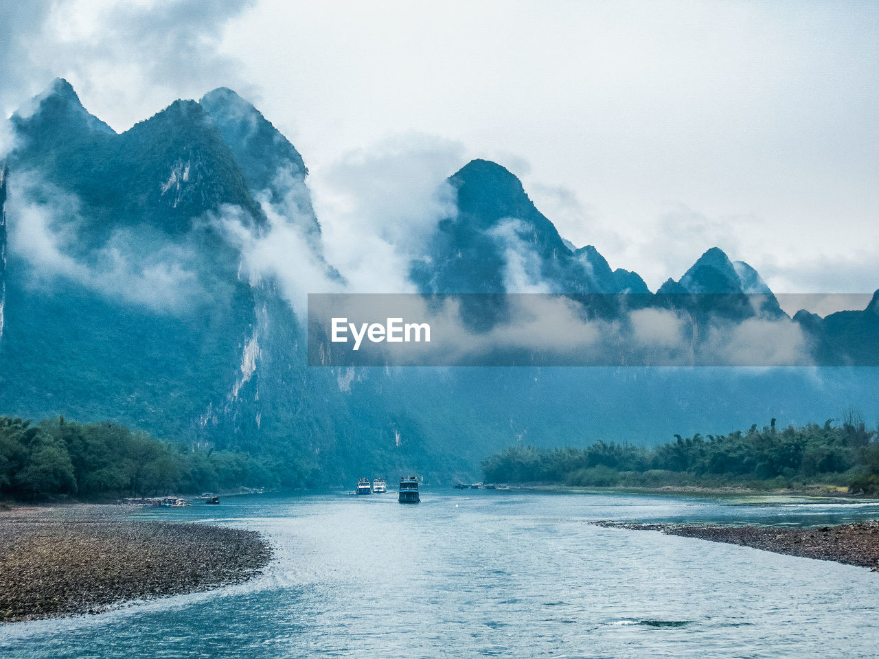 Scenic view of sea and mountains against sky