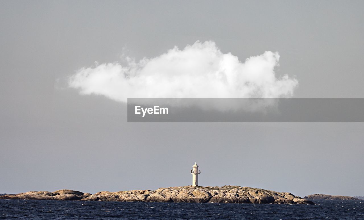 Scenic view of rock by sea against sky