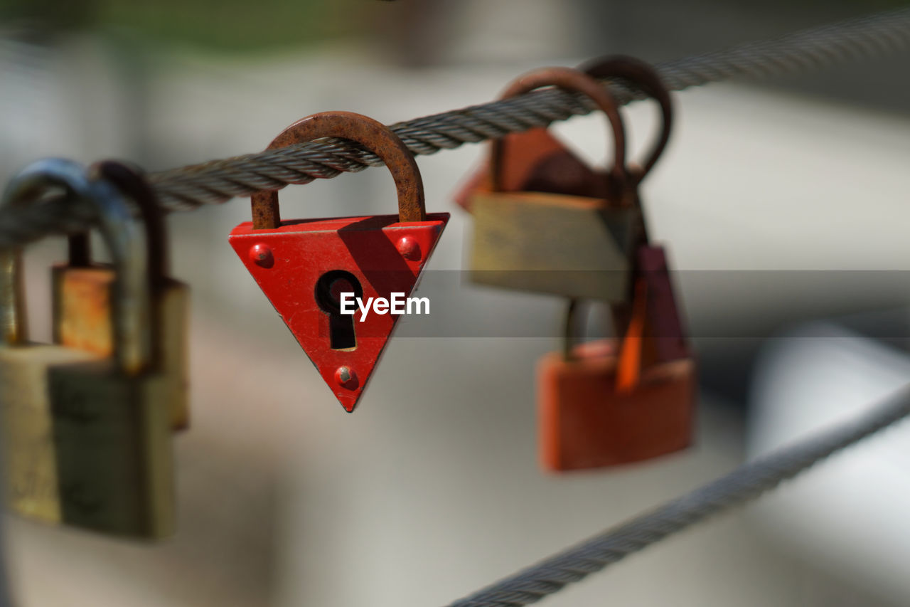 Close-up of love locks hanging on steel cable