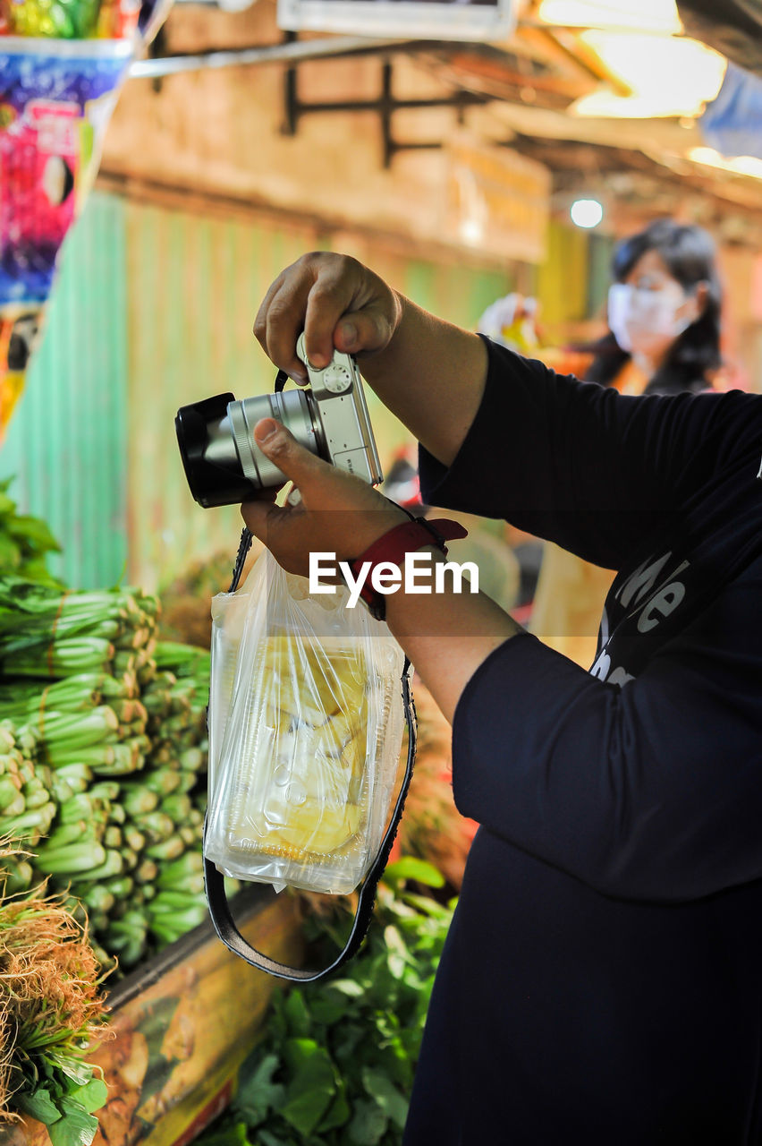 adult, food and drink, one person, occupation, holding, business, food, women, business finance and industry, retail, standing, market, working, person, technology, healthy eating, small business, female, freshness, container, lifestyles, fruit, waist up