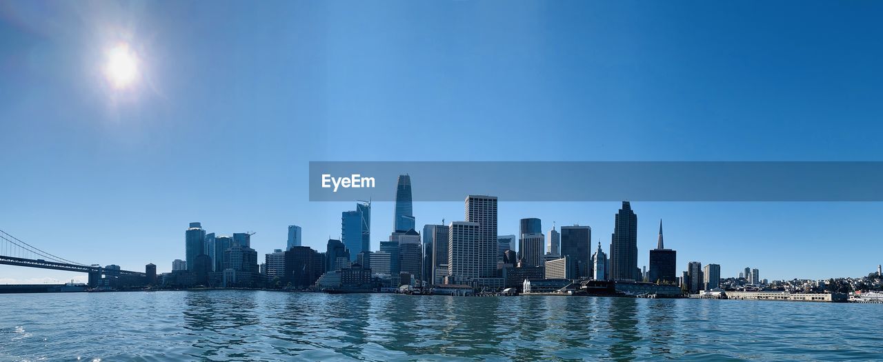 RIVER AMIDST BUILDINGS AGAINST SKY IN CITY