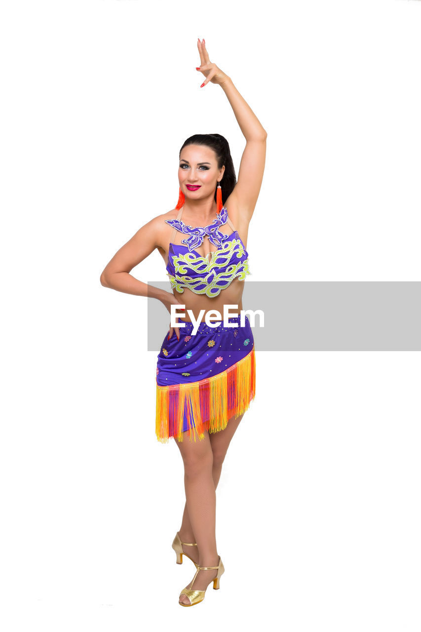 full length, one person, white background, studio shot, women, portrait, arm, young adult, limb, smiling, adult, human limb, cut out, happiness, fashion, clothing, indoors, looking at camera, front view, arms raised, emotion, standing, cheerful, dancing, performing arts, hand, lifestyles, dress, female, arts culture and entertainment, copy space, smile, teeth, gesturing, positive emotion, vitality, looking, sports