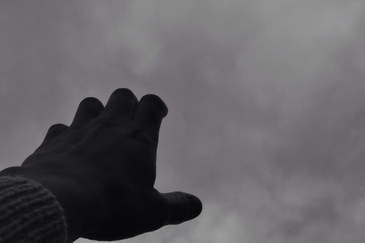 CLOSE-UP OF HUMAN HAND AGAINST SKY