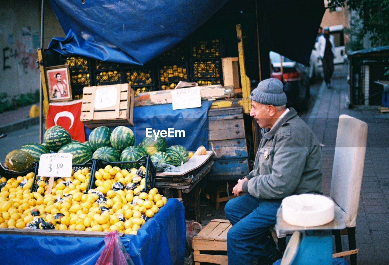 Side view of man selling fruits in market
