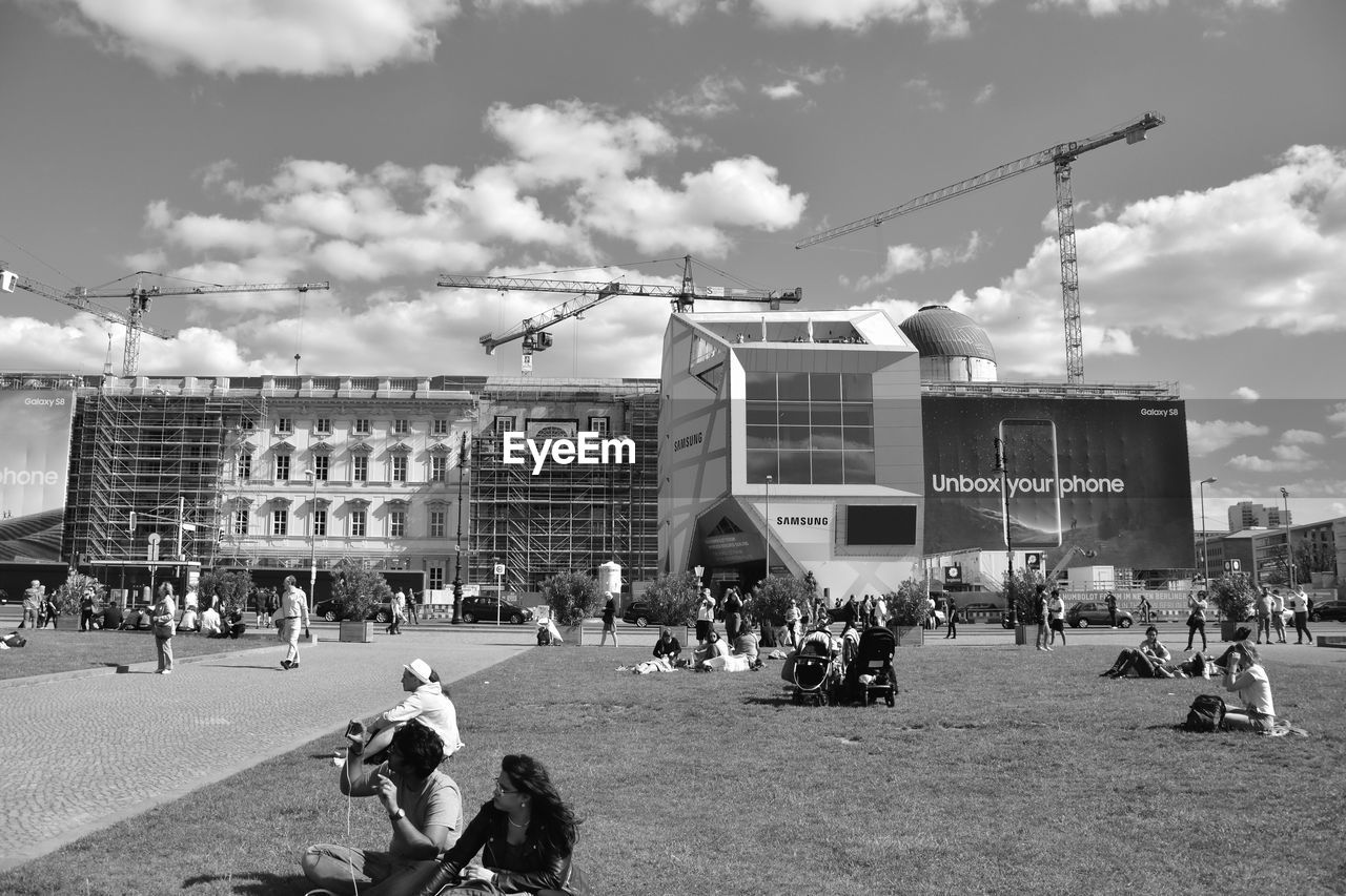 PEOPLE IN TOWN SQUARE AGAINST SKY