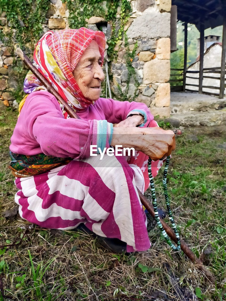 Full length of woman sitting in pink yard