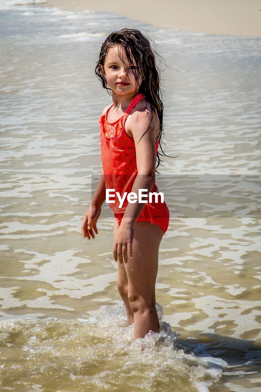 side view of young woman standing in water