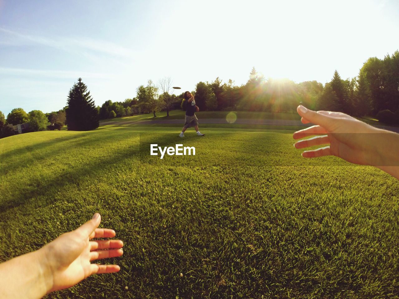 Couple playing with plastic disc on grassy field